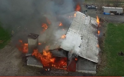 an aerial view of a barn on fire