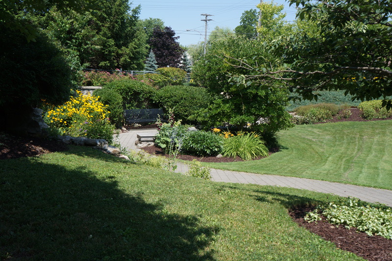 a lawn with flower beds in Millennium Garden in Puslinch, Ontario