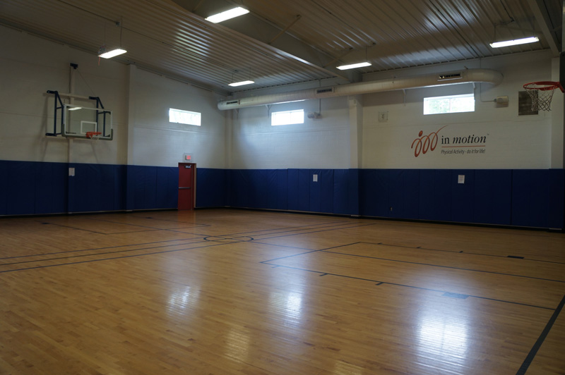 An empty gymnasium with a basketball court