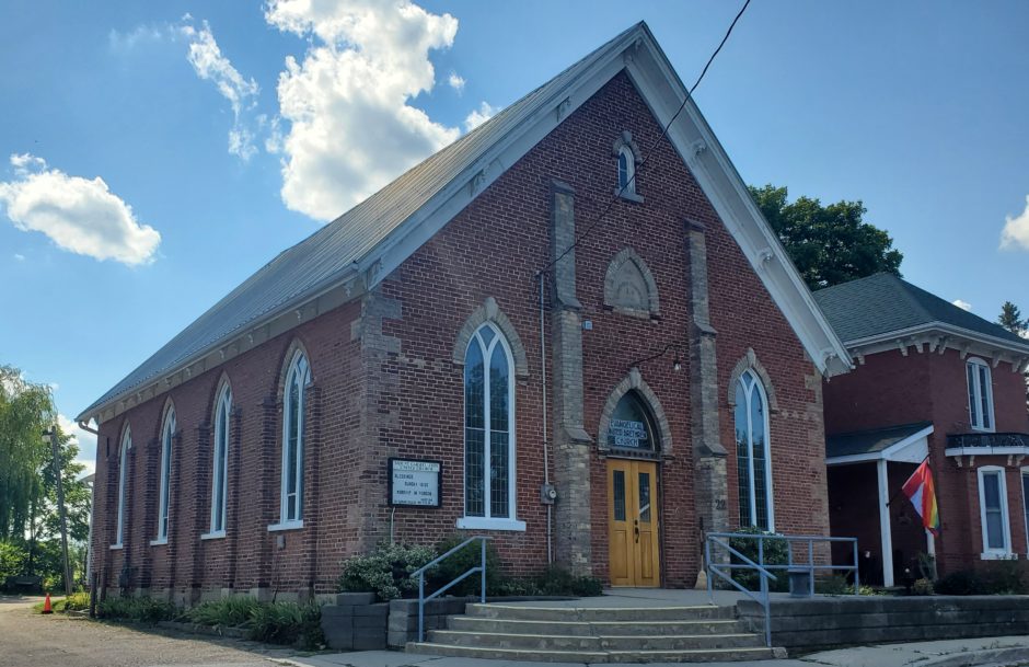 Side view of the German Evangelical Church located at 22 Victoria Street, Lot 31, Rear Concession 7, Morriston, Puslinch, Ontario. Red brick, one storey, heritage property.