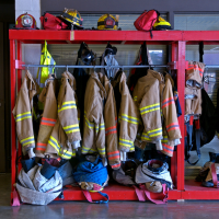 Firefighter equipment and suits handing on a rack. 